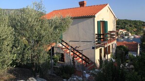 A building with a red-tiled roof, a staircase, and a balcony. - Apartment Iva (Konavle)