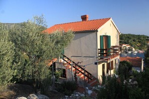 A building with a red-tiled roof, a staircase, and a balcony. - Apartment Iva (Konavle)
