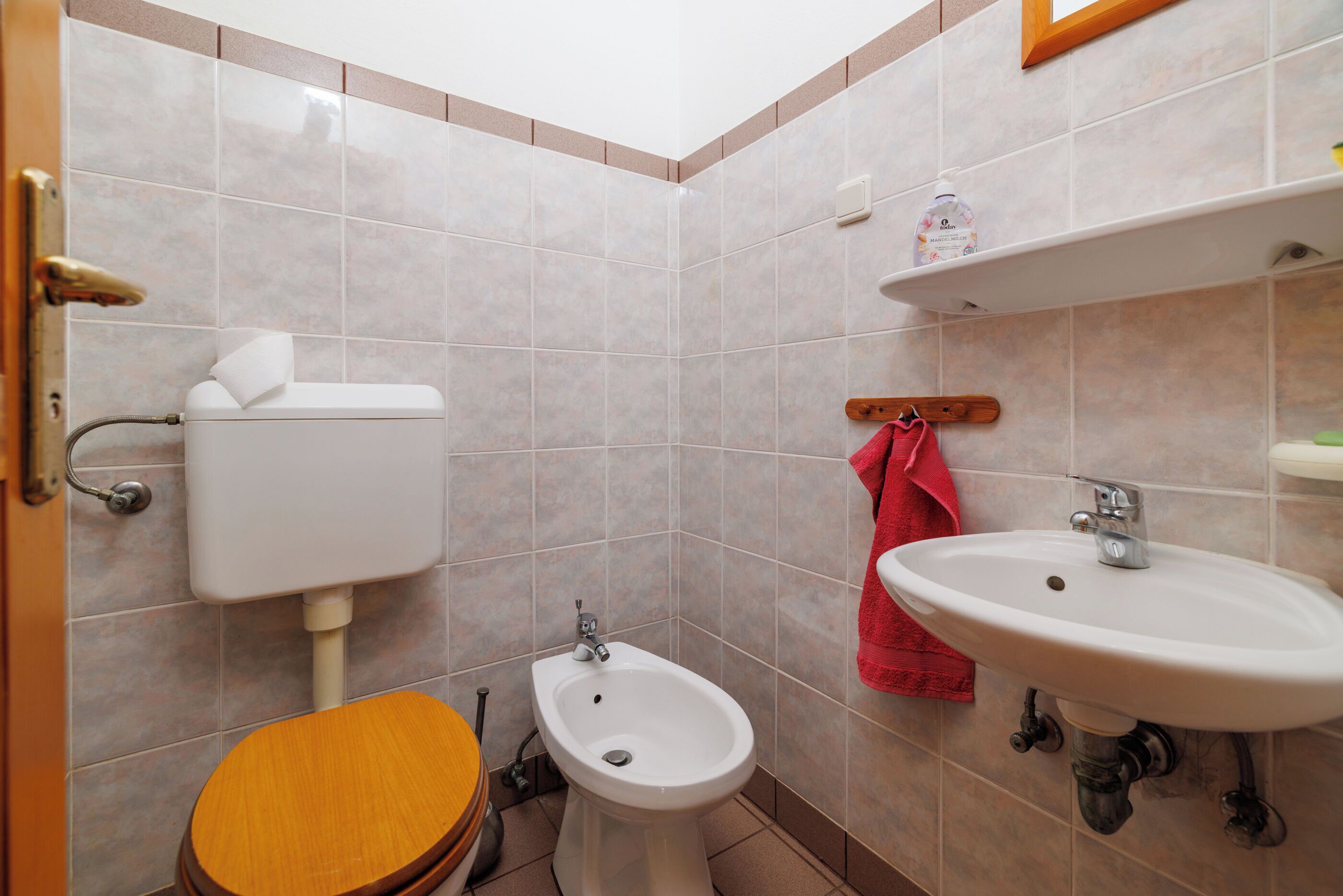 A bathroom with a toilet, bidet, and sink.