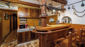 Una cucina rustica con mobili in legno, un'isola centrale e un lampadario a sospensione.