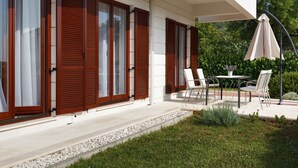 Una casa moderna con ampie finestre e un patio arredato.