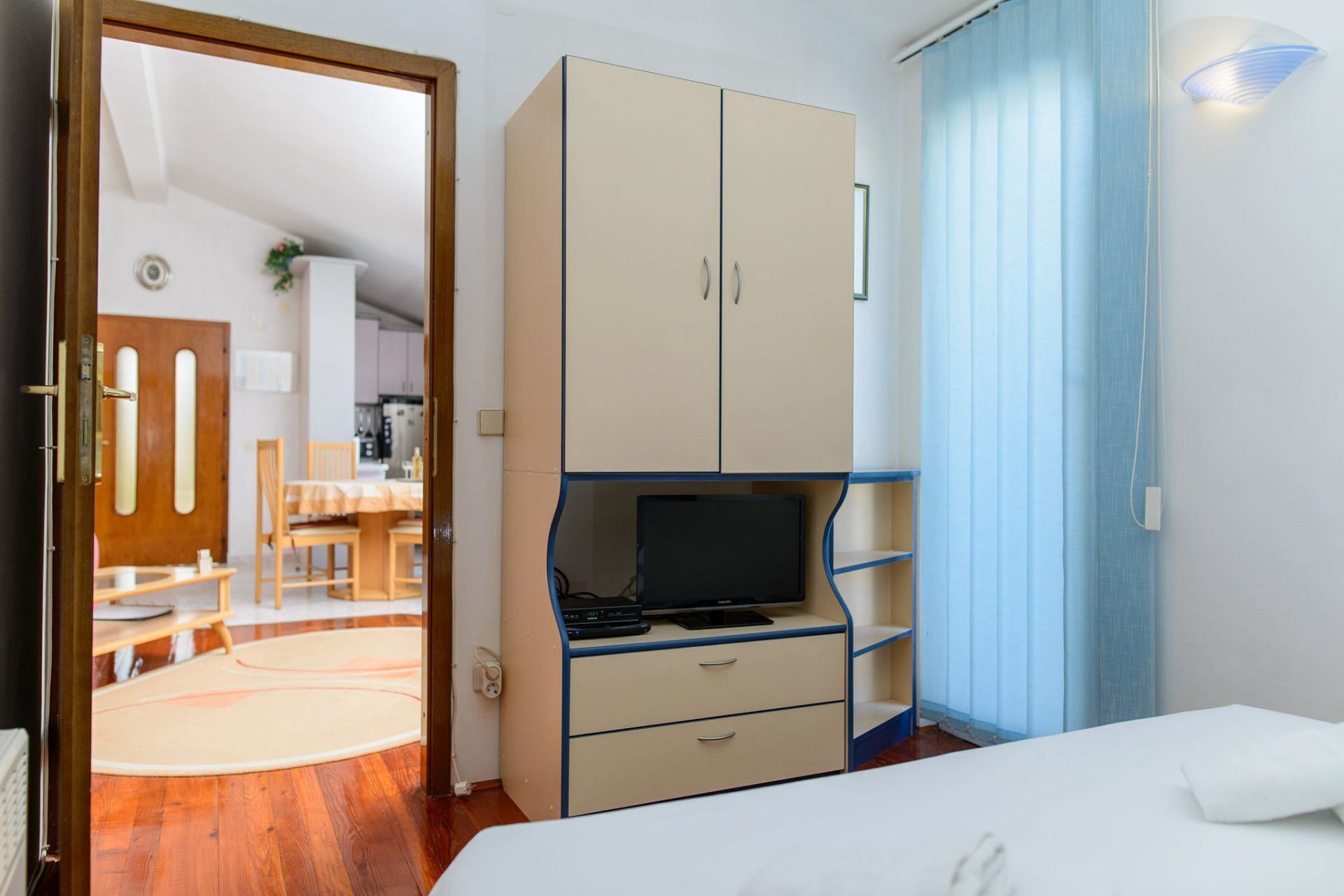 A room with a bed, a TV, a wardrobe, and a desk.