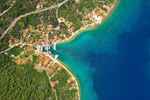 An aerial view of a coastal town with houses, a marina, and a clear blue sea. - House Vese (Zadar)