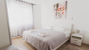 Une chambre à coucher moderne avec un grand lit, une table de chevet avec une lampe et un tableau au mur.