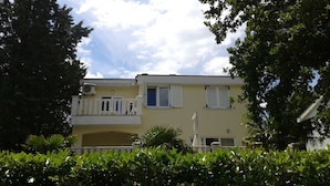 A two-story building with balconies, air conditioning units, and a clear sky. - Apartments Pondeljak (Malinska-Dubasnica)