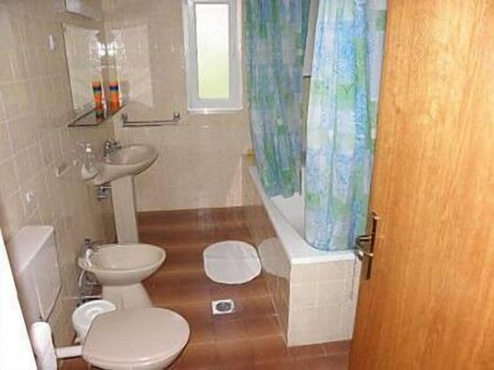 A bathroom with a toilet, bidet, sink, and bathtub.