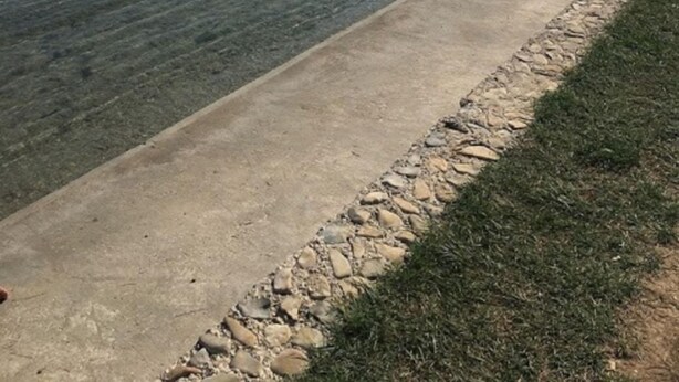 A waterfront with a concrete walkway and a grassy area. - Apartments Andy (Sukosan)