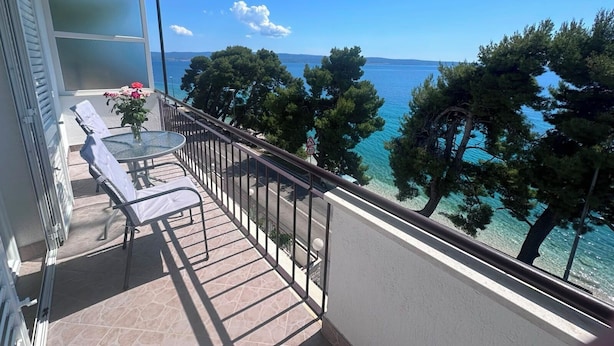 A balcony with a table, chairs, and a view of the sea. - Apartment Verica (Dugi Rat)