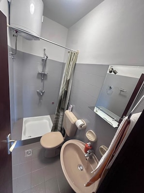 A bathroom with a bathtub, toilet, sink, shower, and a mirror. - Apartment Verica (Dugi Rat)