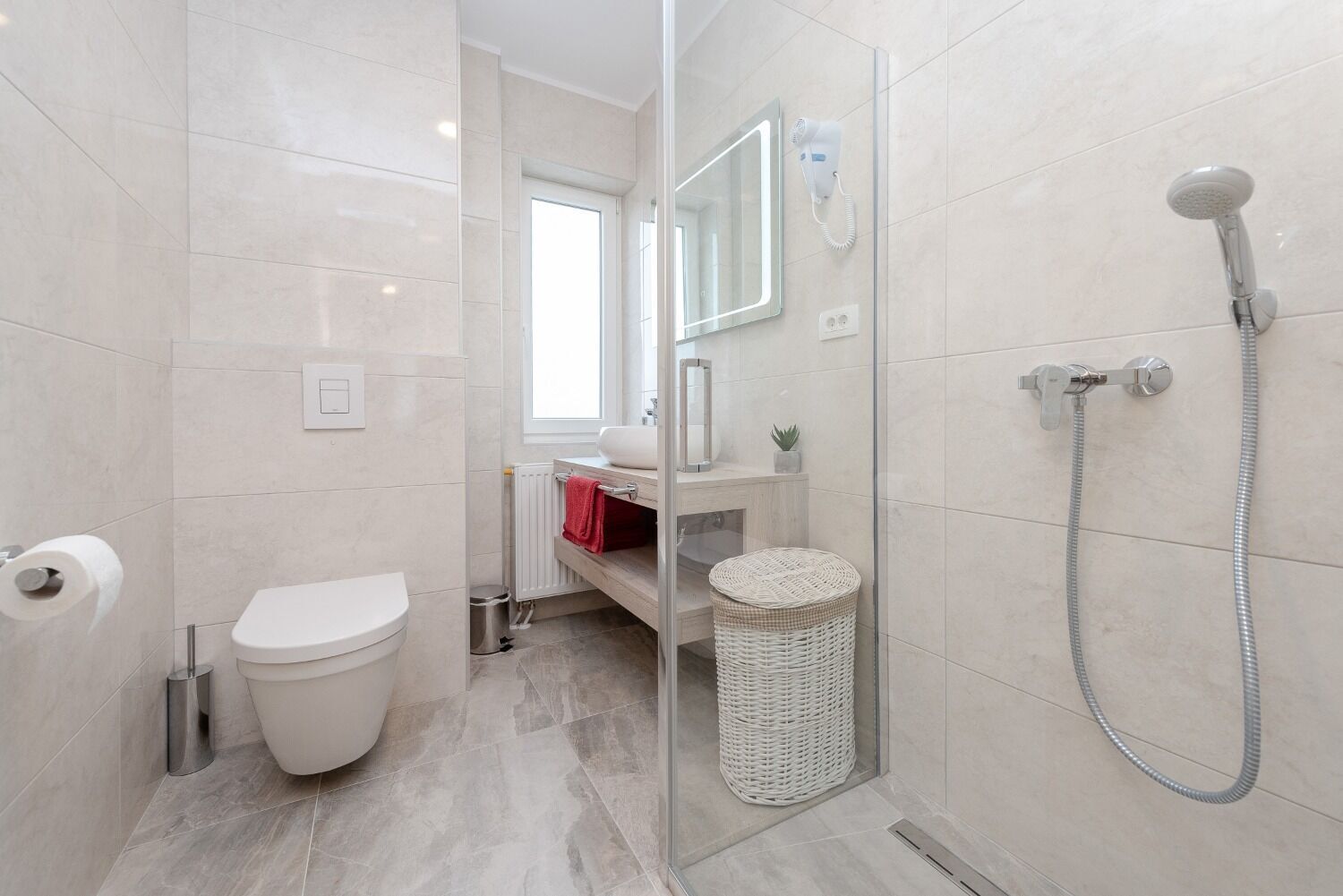 Ein modernes Badezimmer mit Toilette, Waschbecken und Dusche.