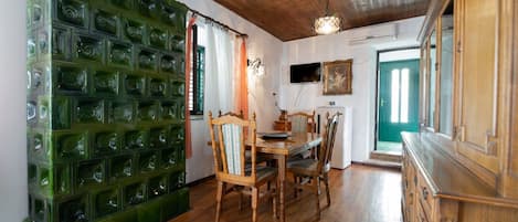 A dining area with a wooden table, chairs, and a green decorative wall.