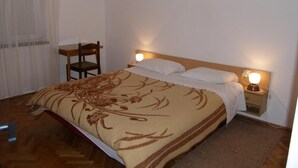 A bedroom with a bed, bedside table, lamp, chair, and a painting on the wall. - Apartments Mirko (Tkon)