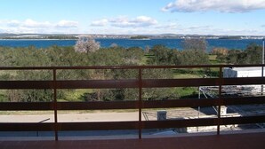 A balcony with a view of a coastal landscape, including a body of water and distant land. - Apartments Mirko (Tkon)