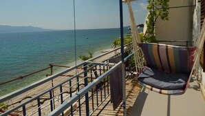 A balcony with a view of the sea, a hammock, and a railing. - Apartment Inga (Gradac)