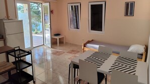 A compact room with a kitchenette, a dining area, and a bed. - Apartments Var (Hvar)
