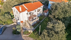 A multi-story building with a red-tiled roof, a balcony, and a garden area. - Apartments Mari (Zadar)