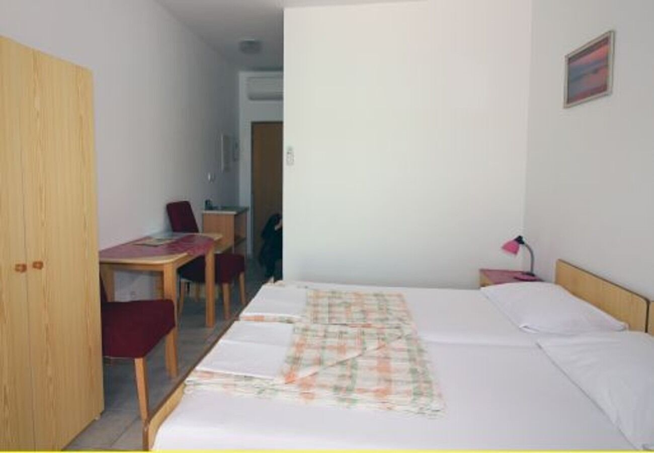 A bedroom with a bed, a desk, and a chair.