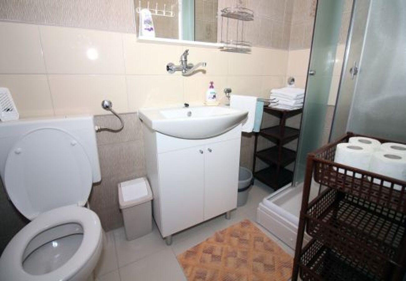 A bathroom with a toilet, sink, and shower.