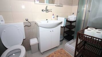 A bathroom with a toilet, sink, and shower.