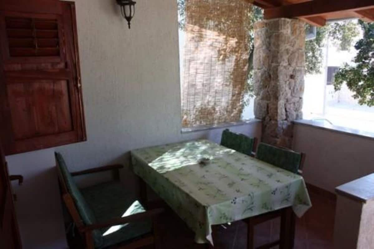 Une petite pièce avec une table et des chaises, une fenêtre donnant sur un beau paysage et une porte en bois.