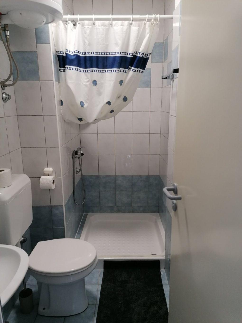 A small bathroom with a toilet, a shower, and a bathtub.