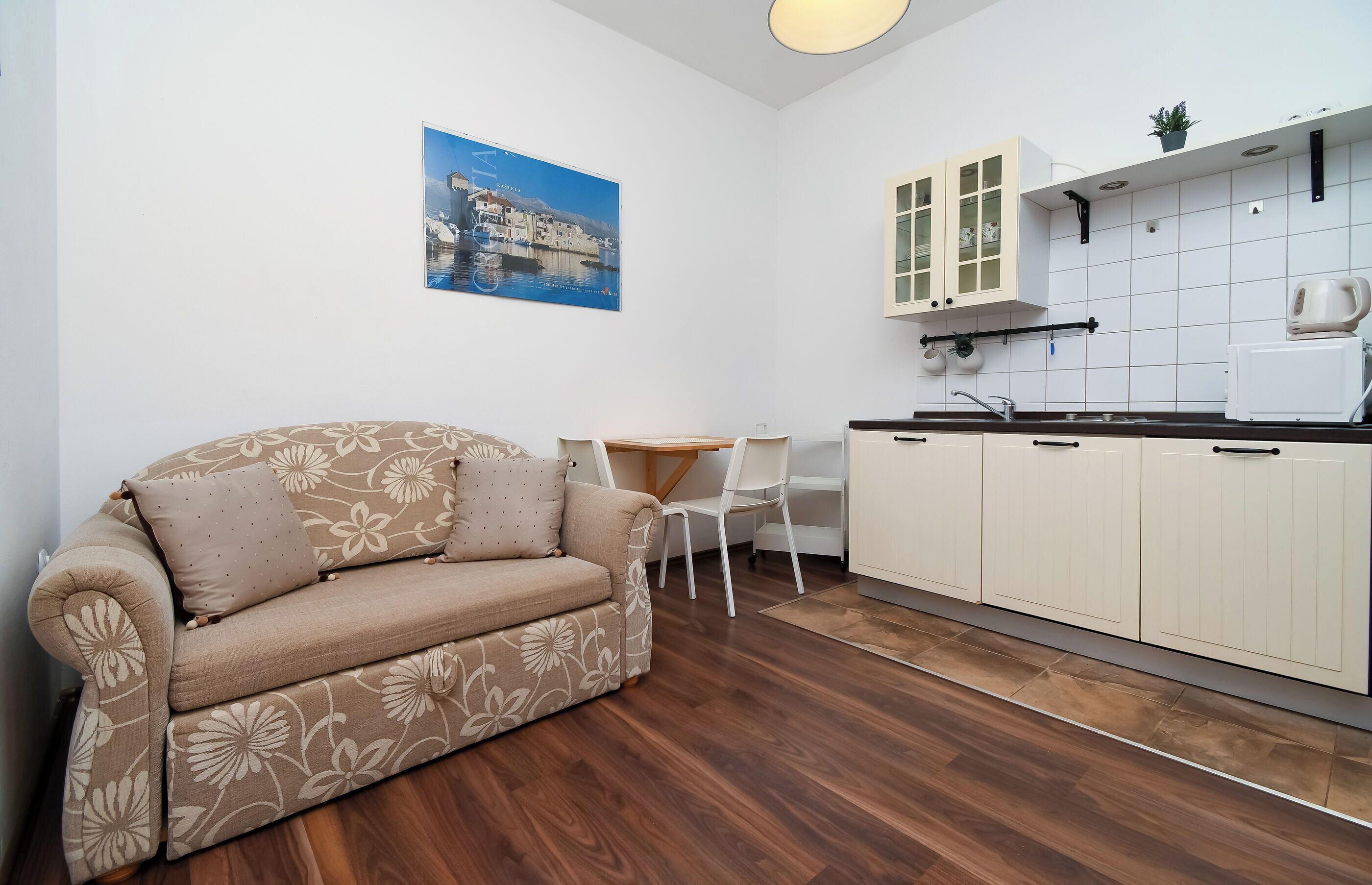 A compact living space with a sofa, a dining table, and a kitchenette.