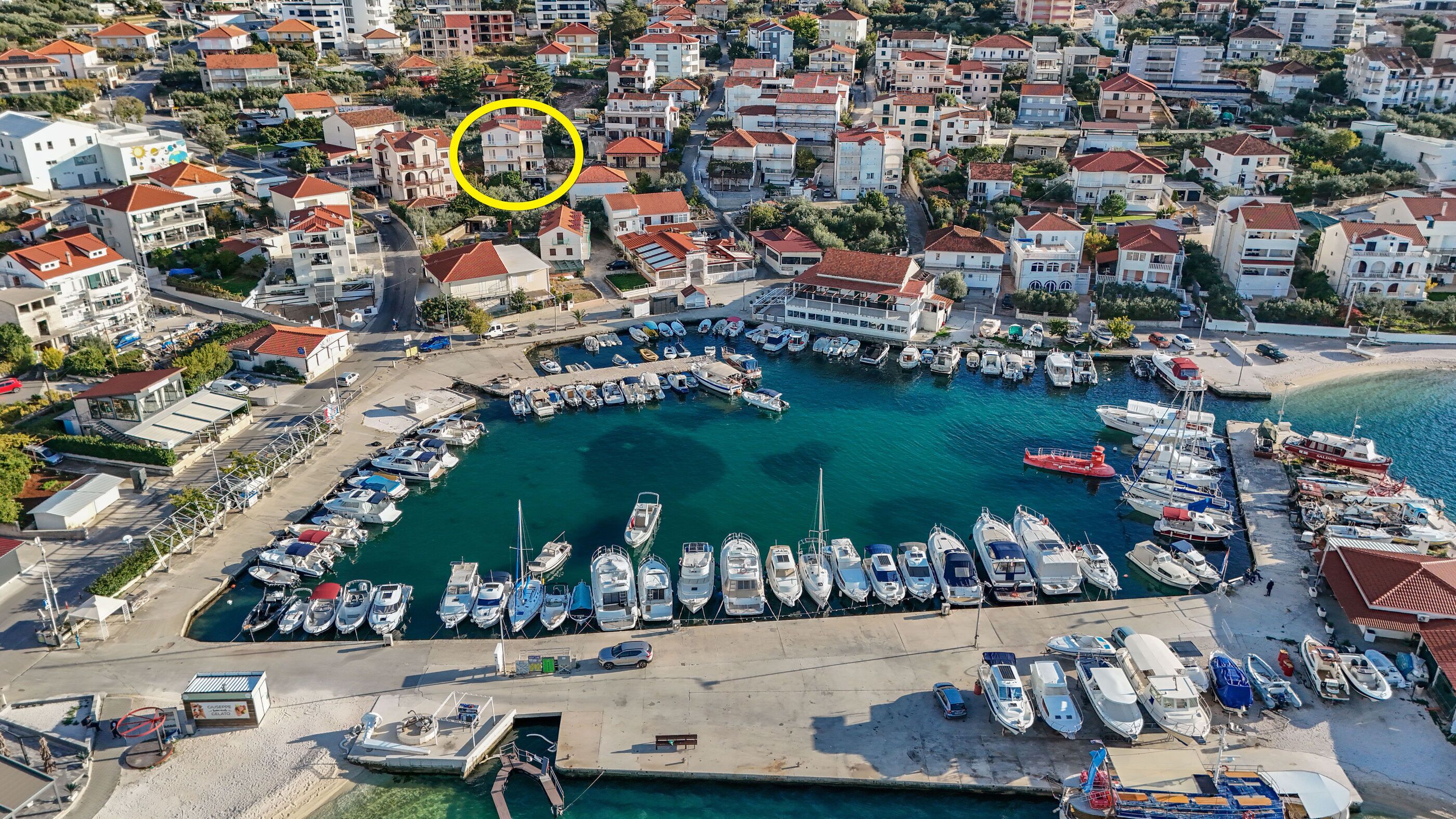 Vue aérienne d’une marina entourée d’immeubles résidentiels.