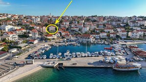 Marina com barcos atracados, rodeada por edifícios residenciais com telhados vermelhos.