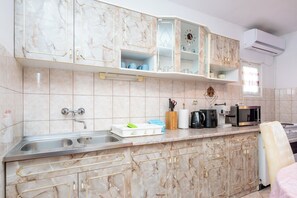 Eine Küche mit Marmor-Schränken, einer Spüle, einer Mikrowelle und einer Kaffeemaschine.