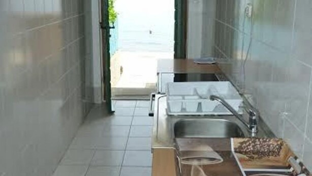 A narrow kitchen with a sink, cabinets, and a countertop. - House Kuca za Odmor (Preko)