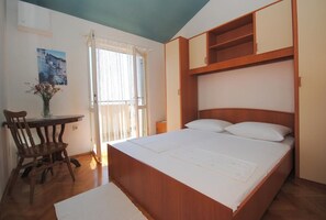 Ein Schlafzimmer mit einem hölzernen Bett, einem Schreibtisch und einem Stuhl.