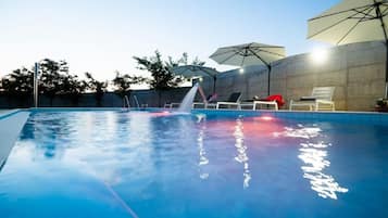 Outdoor pool, an infinity pool, pool umbrellas, sun loungers