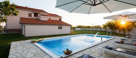 Una piscina al aire libre, una piscina infinita, sombrillas