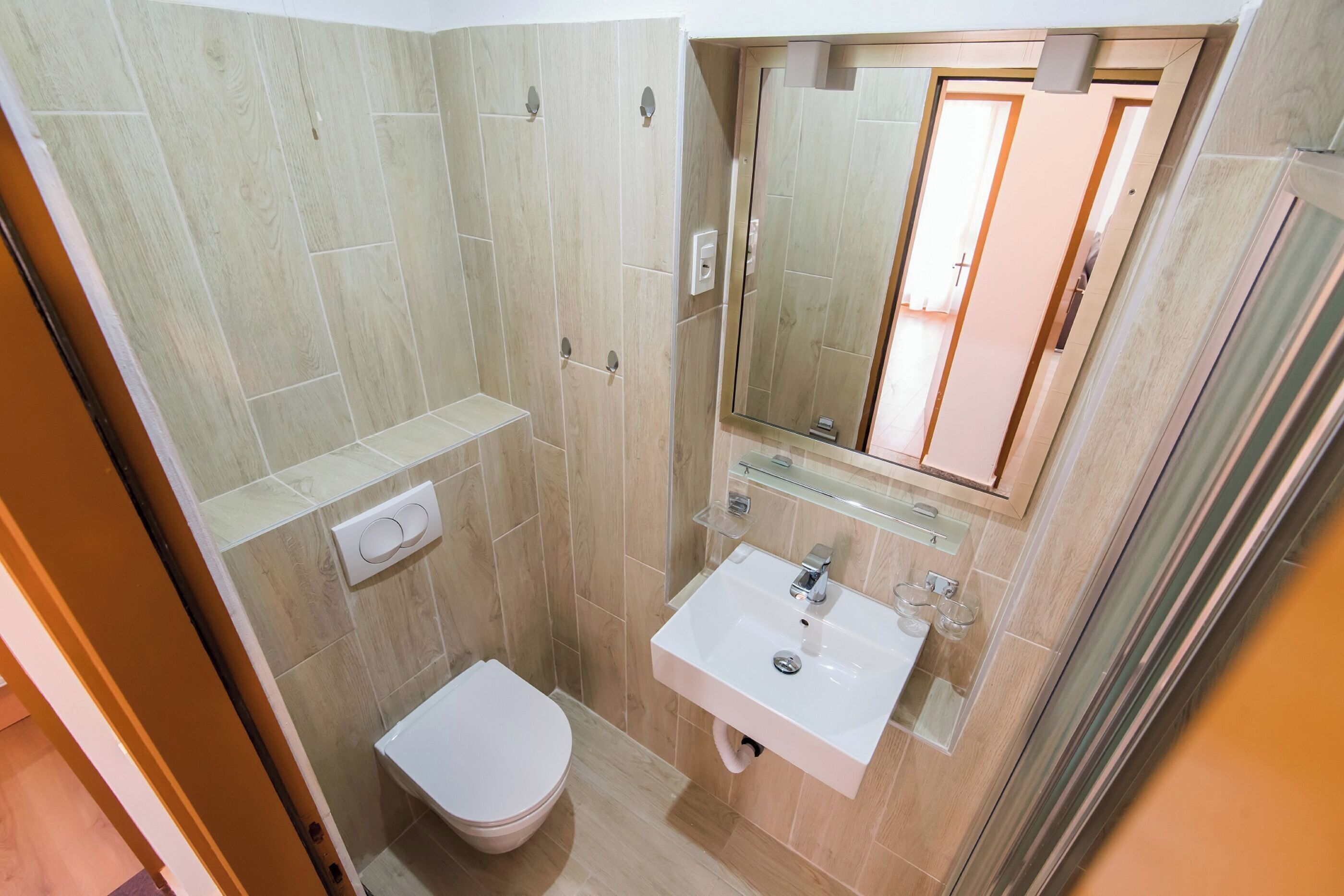 Une salle de bain avec des toilettes, un lavabo et une douche.