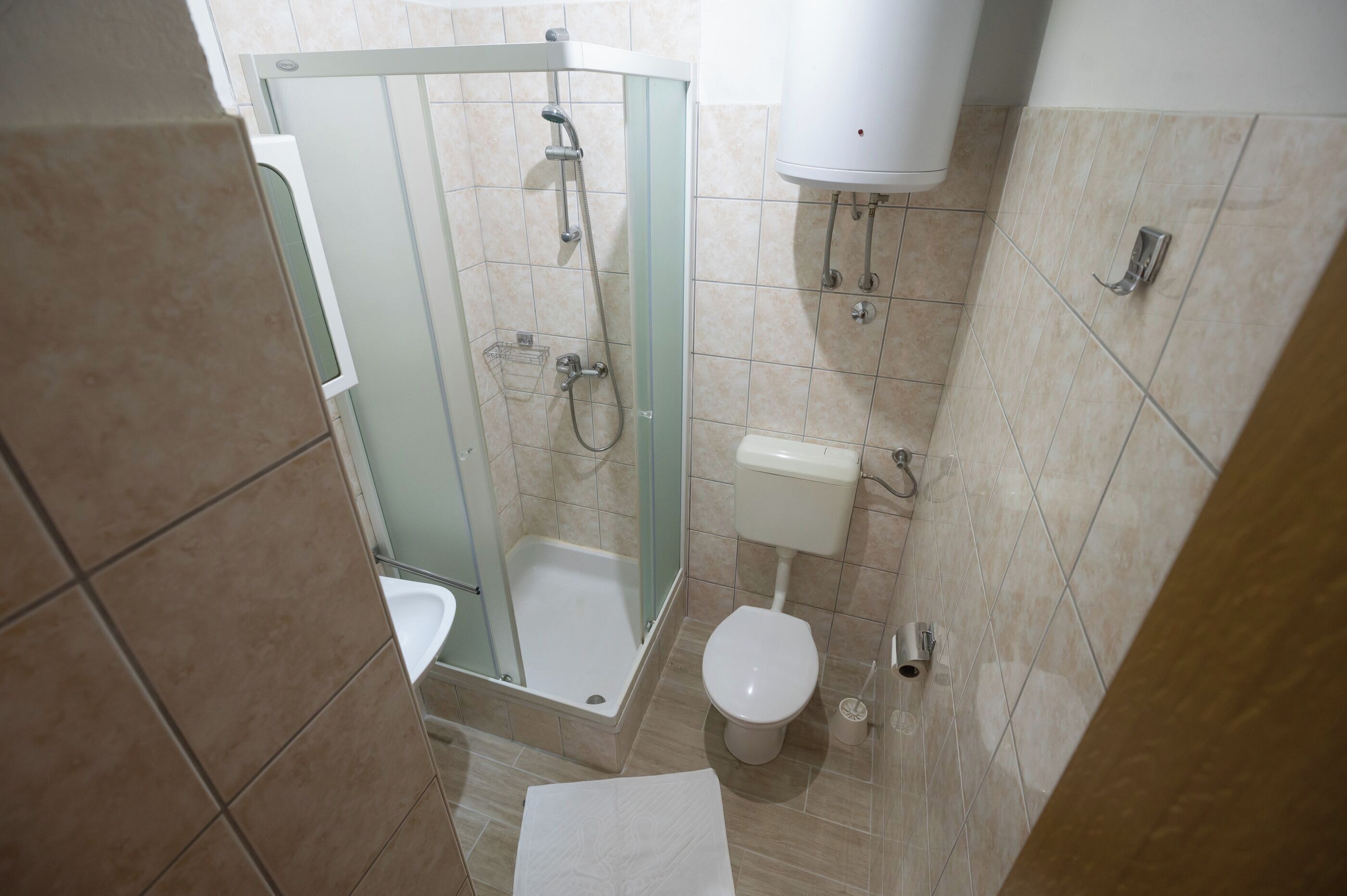 A bathroom with a shower, toilet, and sink.