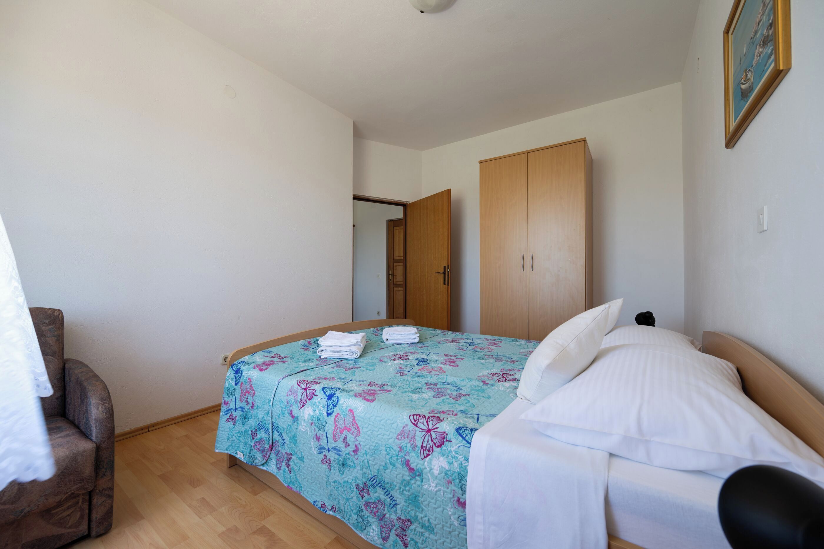 Une chambre à coucher avec un lit, une armoire en bois et une chaise.