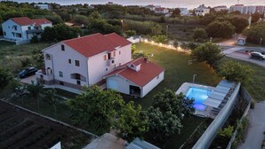 A residential area with houses, a swimming pool, and a road. - Apartments Armitage (Privlaka)