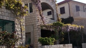 Un edificio de piedra con un balcón, una ventana y una puerta.