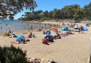 Ein Strand mit Zelten und entspannten Menschen.