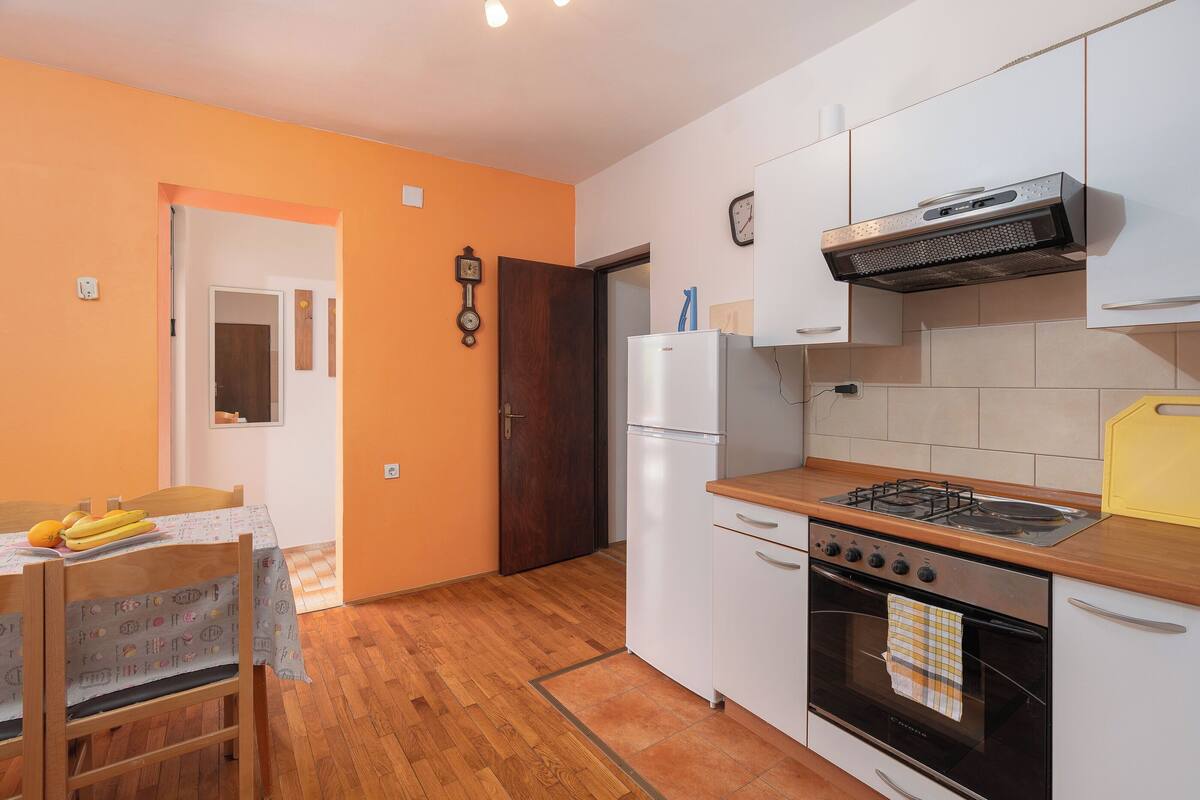 Une cuisine de taille réduite équipée d’une cuisinière, d’un four et d’un réfrigérateur.