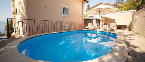 Piscine extérieure, parasols, chaises longues