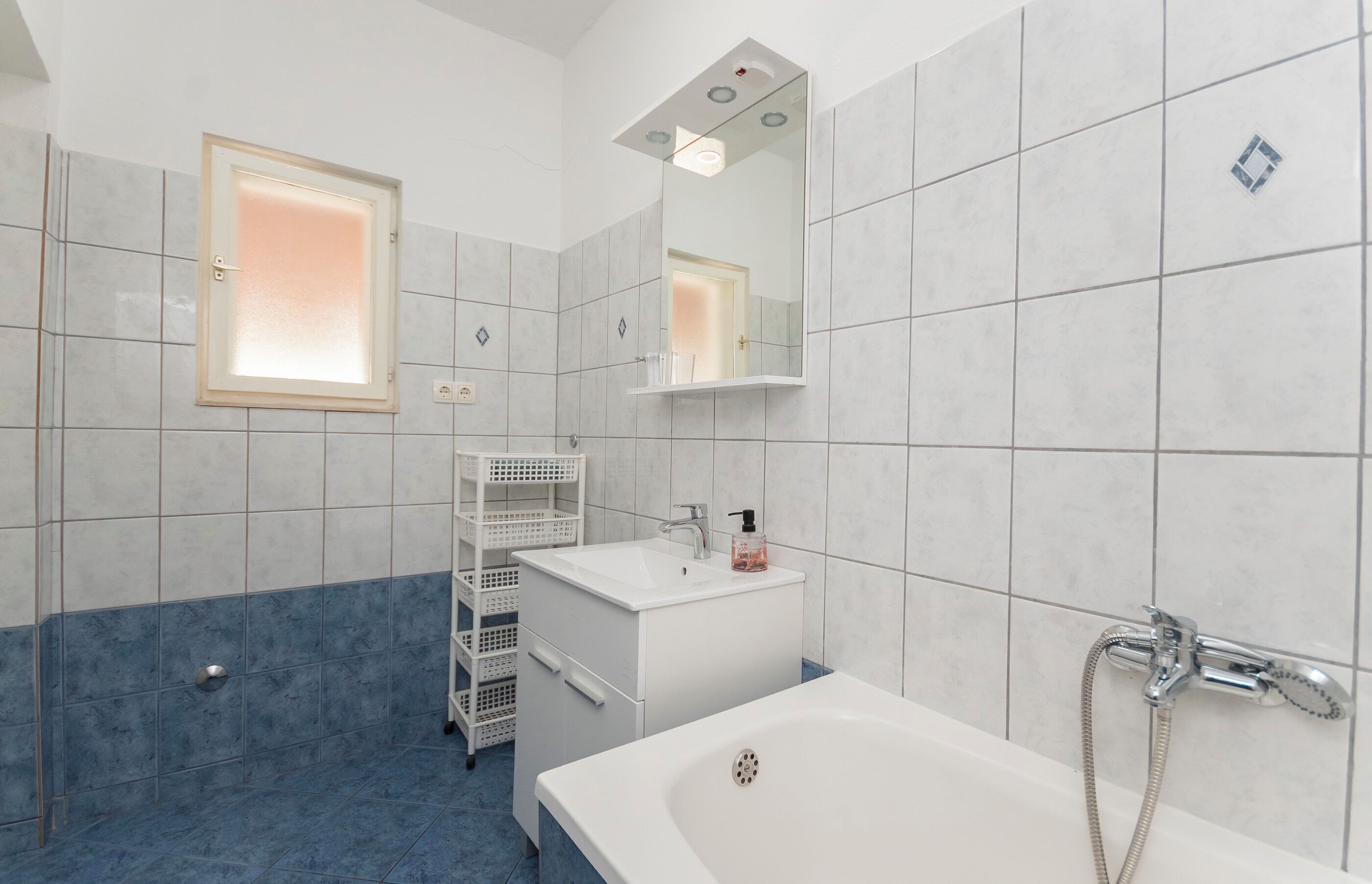 Une salle de bain moderne équipée d’une baignoire, d’un lavabo, d’un miroir et d’une douche.