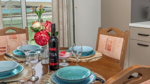 A dining table set with blue plates, wine glasses, and a bottle of red wine. - Apartment Don (Pag)