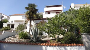 A residential building with a white facade, red-tiled roof, and a balcony. - Apartments Marija (Murter-Kornati)