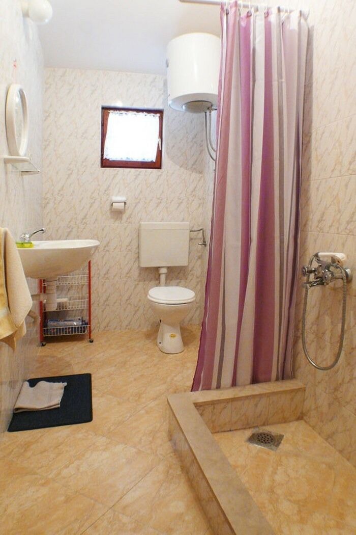 Ein Badezimmer mit Dusche, Toilette und Waschbecken.