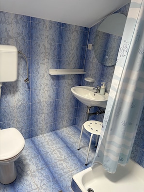 Ein Badezimmer mit Toilette, Waschbecken und Duschvorhang.