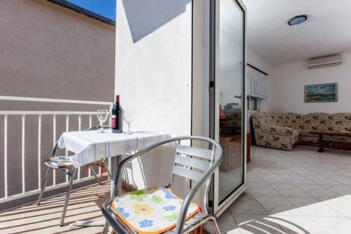 Ein Balkon mit Tisch, Stühlen und einer Couch.