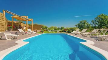 Una piscina al aire libre, sombrillas