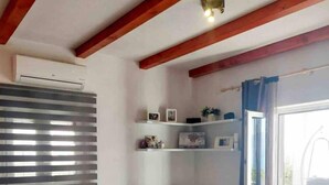 A living room with a beige sectional sofa, a white coffee table, and a built-in shelf with decorative items. - House Ita (Postira)