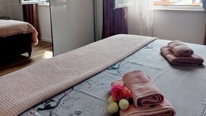 A bedroom with a bed, a mirror, a window with a view, and a bedside table with towels. - Apartments Ita 1 (Postira)